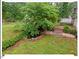 Beautifully landscaped backyard with a pond and mature trees and lush greenery at 216 Brook Ln, Durham, NC 27712