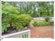 Brick patio in a shady backyard with mature trees, landscaping and a privacy fence at 216 Brook Ln, Durham, NC 27712