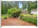 Expansive backyard with brick patio, mature trees, landscaping, a shed, and a fire pit at 216 Brook Ln, Durham, NC 27712