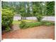 Spacious backyard patio with mature trees, landscaping, a shed and privacy fence at 216 Brook Ln, Durham, NC 27712