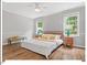 Bright bedroom featuring hardwood floors, two windows, ceiling fan, and neutral color scheme at 216 Brook Ln, Durham, NC 27712