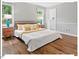 Light-filled bedroom with hardwood floors, two large windows, and a neutral color palette at 216 Brook Ln, Durham, NC 27712