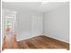 Bedroom with wood floors, closet, and view into other room at 216 Brook Ln, Durham, NC 27712