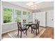 Charming dining area with a round glass table, wood chairs, and natural light from large windows overlooking the yard at 216 Brook Ln, Durham, NC 27712