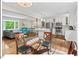 Bright dining area with glass table, modern lighting, and hardwood floors adjacent to an open living space and kitchen at 216 Brook Ln, Durham, NC 27712