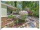 Landscaped yard with driveway leading to a covered carport and views of the light green home at 216 Brook Ln, Durham, NC 27712