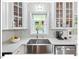 The kitchen features a stainless steel sink, white countertops, matching cabinets, and contemporary backsplash at 216 Brook Ln, Durham, NC 27712