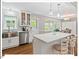 Updated kitchen with stainless steel appliances, white cabinetry, an island, and dining area with views of the backyard at 216 Brook Ln, Durham, NC 27712