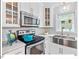 Close-up of the bright kitchen with stainless steel appliances, marble backsplash, and window with a view at 216 Brook Ln, Durham, NC 27712
