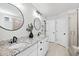 Modern bathroom features a double vanity with granite countertop, two round mirrors, and a glass door shower at 2634 Turner Pines Dr, New Hill, NC 27562