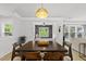 Bright dining area features a wooden table, decorative lighting, and views into a cozy sitting room at 2634 Turner Pines Dr, New Hill, NC 27562