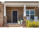 Inviting front porch with brick columns, rocking chairs, and potted flowers creating a warm entrance at 2634 Turner Pines Dr, New Hill, NC 27562