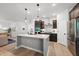 Bright kitchen featuring an island, stainless steel appliances, and wood flooring at 2634 Turner Pines Dr, New Hill, NC 27562