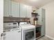 Well-organized laundry room with cabinets, a washer, dryer, and folding counter, great for chores at 2634 Turner Pines Dr, New Hill, NC 27562