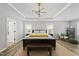 Inviting main bedroom with tray ceilings, modern chandelier, and wood-look flooring at 2634 Turner Pines Dr, New Hill, NC 27562