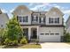 Charming two-story home with a manicured lawn, a two car garage and elegant gray and white color scheme at 2885 Farmhouse Dr, Apex, NC 27502