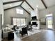 Open-concept living room featuring vaulted ceilings, beams, fireplace, and an abundance of natural light at 2885 Farmhouse Dr, Apex, NC 27502
