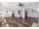 Open-concept living room flowing into the kitchen, featuring wood floors, neutral walls, and a staircase at 2885 Farmhouse Dr, Apex, NC 27502