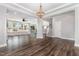 Expansive living area with wood floors, stairs, adjacent kitchen, many large windows, and a stylish chandelier at 2885 Farmhouse Dr, Apex, NC 27502