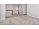Neutral toned upstairs hallway with carpet and wooden railing on stairs at 2885 Farmhouse Dr, Apex, NC 27502