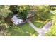 Aerial view of a well-maintained property showcasing a charming home, separate garage, and lush landscaping at 300 Plantation Rd, Clayton, NC 27520