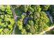 Aerial view of house revealing proximity to roads within its densely wooded area at 300 Plantation Rd, Clayton, NC 27520