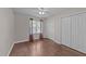 Bedroom features hardwood flooring, a ceiling fan, a window, and large closets at 300 Plantation Rd, Clayton, NC 27520