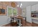Kitchen eating area features a brick wall, large windows, and wainscotting at 300 Plantation Rd, Clayton, NC 27520