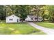 Exterior showcasing a well-manicured lawn, a detached garage, and a long driveway to the house at 300 Plantation Rd, Clayton, NC 27520