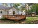A view of the back exterior showcasing the wood deck and exterior of the home and chicken coop at 300 Plantation Rd, Clayton, NC 27520