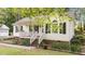 Charming single-story home with a quaint front porch, decorative windows, and manicured landscaping at 300 Plantation Rd, Clayton, NC 27520