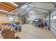 Large garage with high ceilings, equipment, storage, motorcycles, and a workspace at 300 Plantation Rd, Clayton, NC 27520