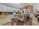 Bright kitchen featuring white cabinetry, stainless steel appliances, and a brick accent wall with a dining area at 300 Plantation Rd, Clayton, NC 27520
