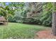 Large backyard featuring a grassy lawn bordered by mature trees and a wooded area at 3007 Krogen Ct, Creedmoor, NC 27522