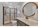 Bathroom featuring a tiled walk-in shower, green vanity with light countertop, and an oval mirror at 3007 Krogen Ct, Creedmoor, NC 27522