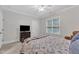 Well-lit bedroom featuring a large window, TV, and comfortable bed with decorative pillows at 3007 Krogen Ct, Creedmoor, NC 27522