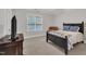 Cozy bedroom with dark wood bed frame, dresser, ceiling fan, and a plush armchair at 3007 Krogen Ct, Creedmoor, NC 27522