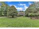 Expansive front yard with mature trees framing a two-story home with lush landscaping at 3007 Krogen Ct, Creedmoor, NC 27522
