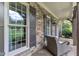 Stone porch with wicker chair and side table and beautiful view of the lush green front lawn at 3007 Krogen Ct, Creedmoor, NC 27522