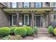 Inviting front porch with stone columns, dark wood accents, and manicured shrubbery at 3007 Krogen Ct, Creedmoor, NC 27522