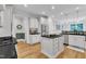 Bright kitchen featuring white cabinets, stainless steel appliances, an island with a black countertop and hardwood floors at 3007 Krogen Ct, Creedmoor, NC 27522