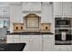 Close up of stainless steel oven and microwave with white cabinets at 3007 Krogen Ct, Creedmoor, NC 27522