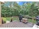 Spacious wooden porch with dark railing and view of a grassy lawn and wooded area at 3007 Krogen Ct, Creedmoor, NC 27522