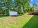 A backyard featuring a storage shed, green grass, and natural shade from mature trees at 3025 Creek Moss Ave, Wake Forest, NC 27587