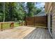 A spacious wooden back deck is enclosed with fencing overlooking a tree-lined yard at 305 Burkwood Ln, Raleigh, NC 27609