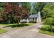 Well-kept gray home featuring a large front yard and mature landscaping at 305 Burkwood Ln, Raleigh, NC 27609