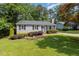 Charming one-story home featuring a well-manicured lawn and lush landscaping at 305 Burkwood Ln, Raleigh, NC 27609
