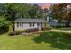 Charming one-story home featuring a well-manicured lawn and lush landscaping at 305 Burkwood Ln, Raleigh, NC 27609