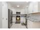 Updated kitchen featuring stainless steel appliances, white cabinetry, and granite countertops at 305 Burkwood Ln, Raleigh, NC 27609