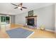 Bright living room with hardwood floors, a fireplace, and a large ceiling fan at 305 Burkwood Ln, Raleigh, NC 27609